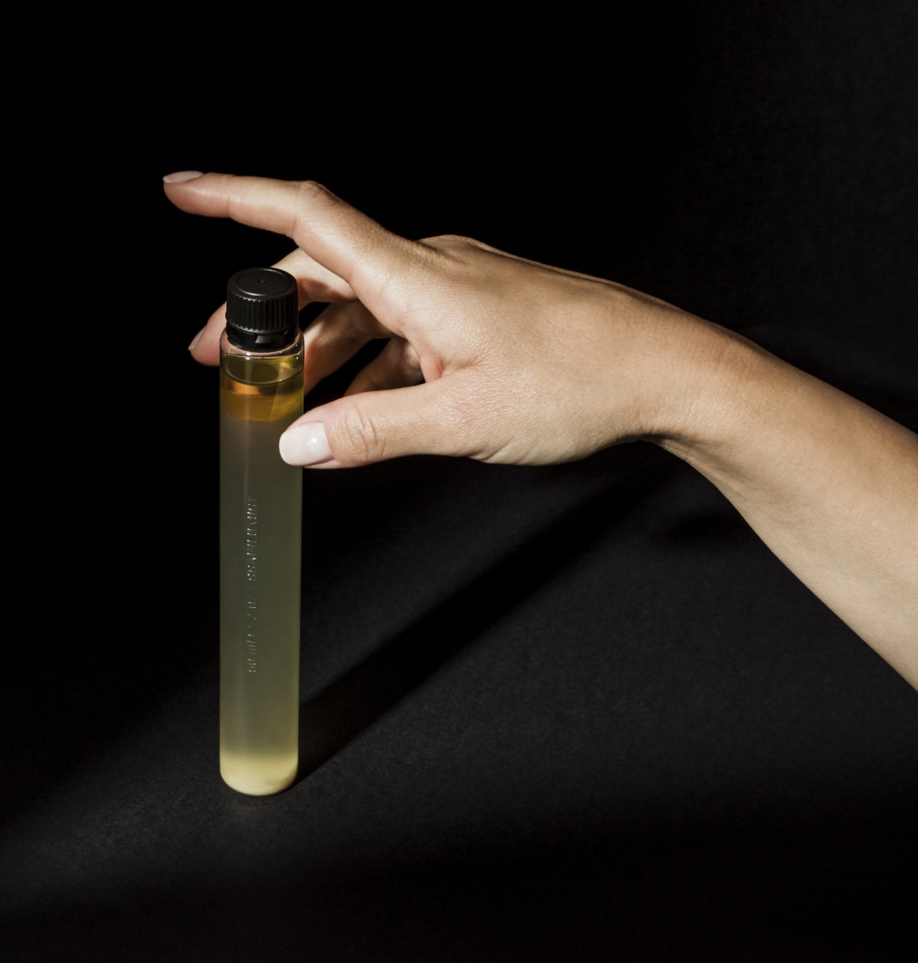 hand reaching for a bottle of DELTA BrainLuxury standing upright on table